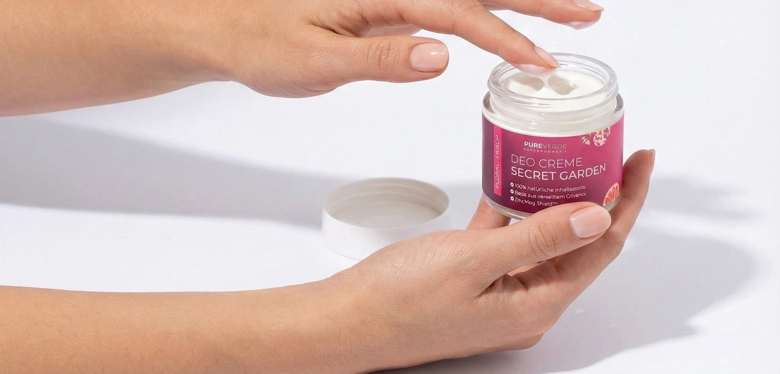 Hände nehmen Creme aus dem Tiegel